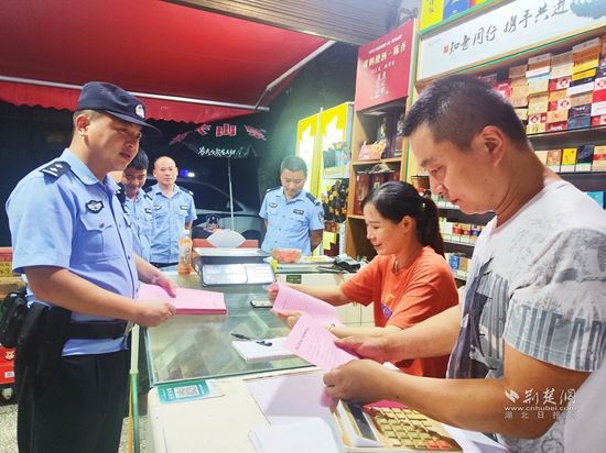 圖為崇陽縣公安局青山派出所民警輔警在轄區沿街商鋪開展反詐宣傳.jpg.jpg